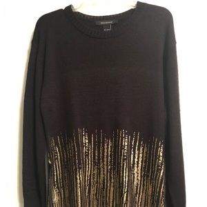 Black sweater with gold accents and slurs on side.